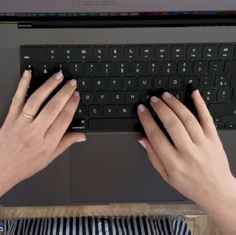 Vue du dessus sur des mains tapant sur le clavier d'un ordinateur pour illustrer la gestion de contenu web